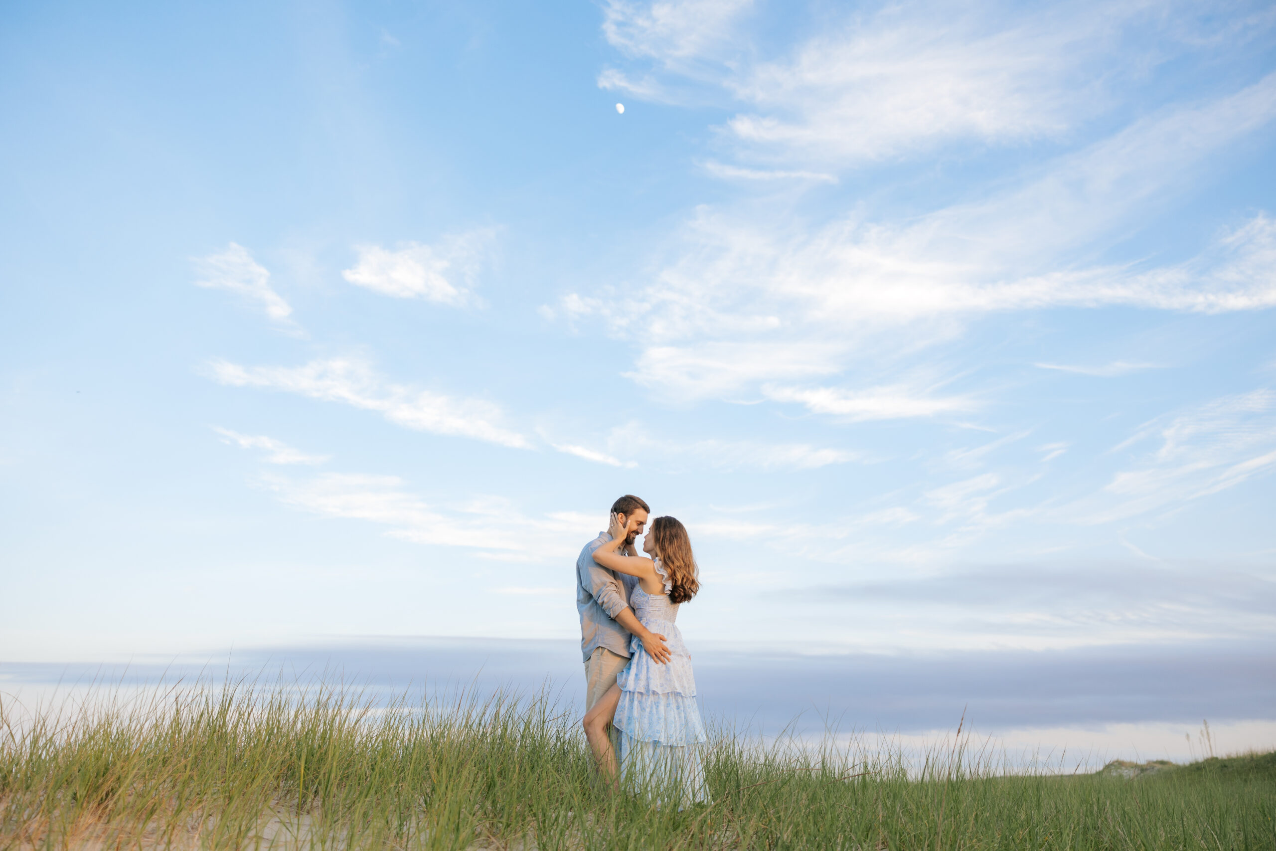 Timeless portrait of engaged couple gazing into each other's eyes on sandy beach in New Jersey